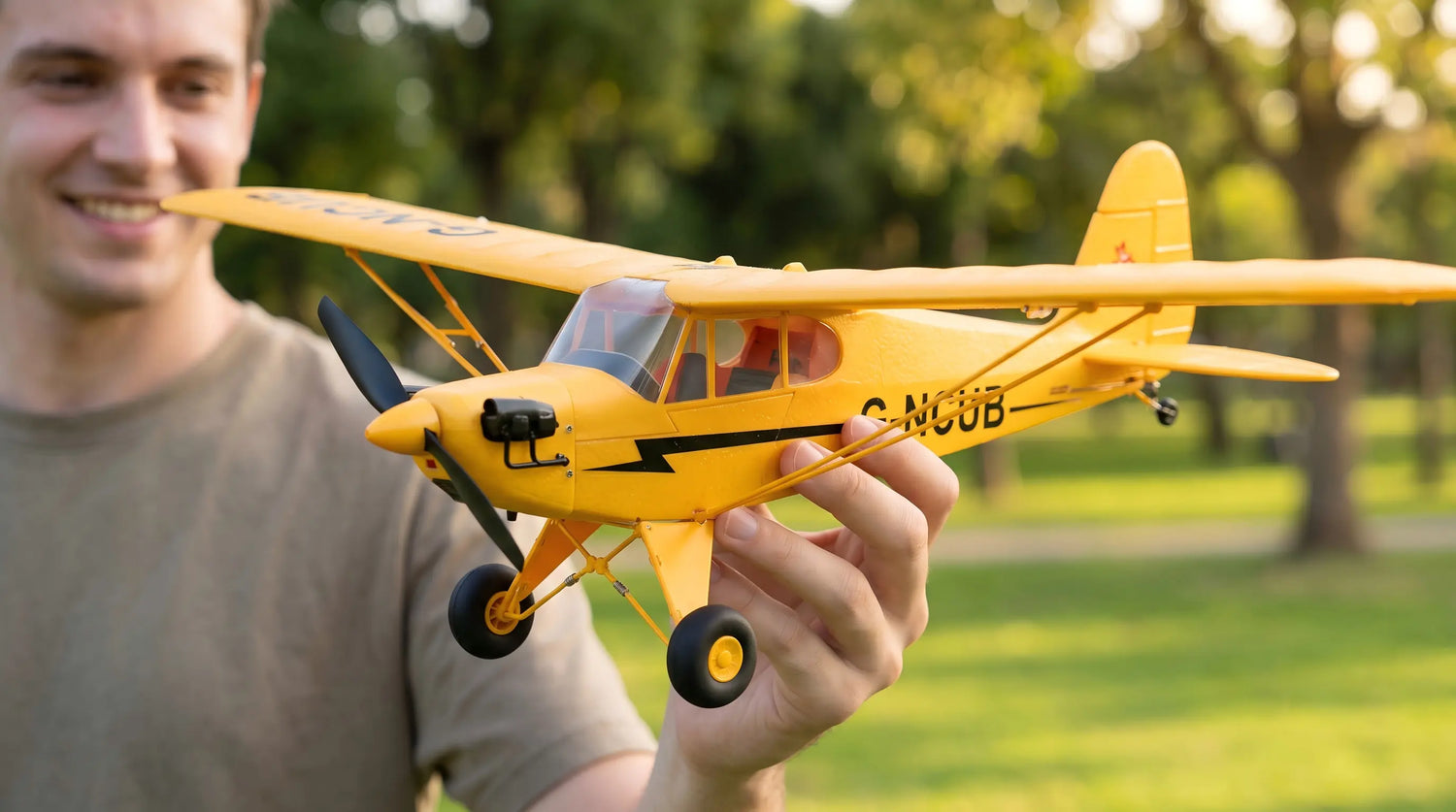 Bright yellow Wei Li XK A160 J-3 Cub RC plane with G-NCUB markings on white background.